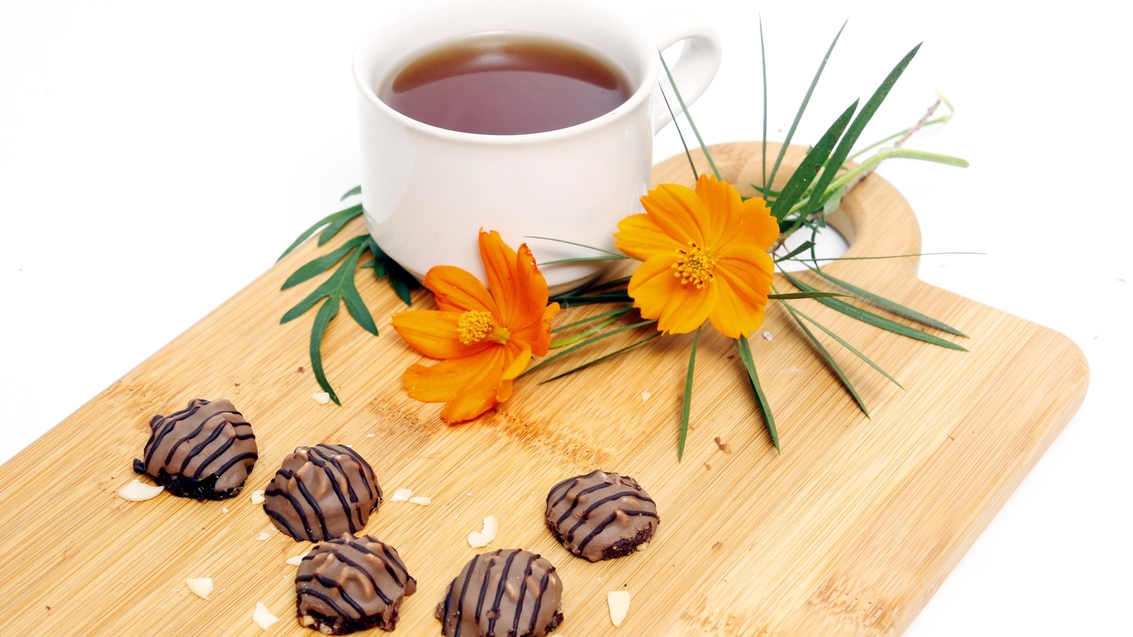 Чашка чая на деревянной доске с конфетами