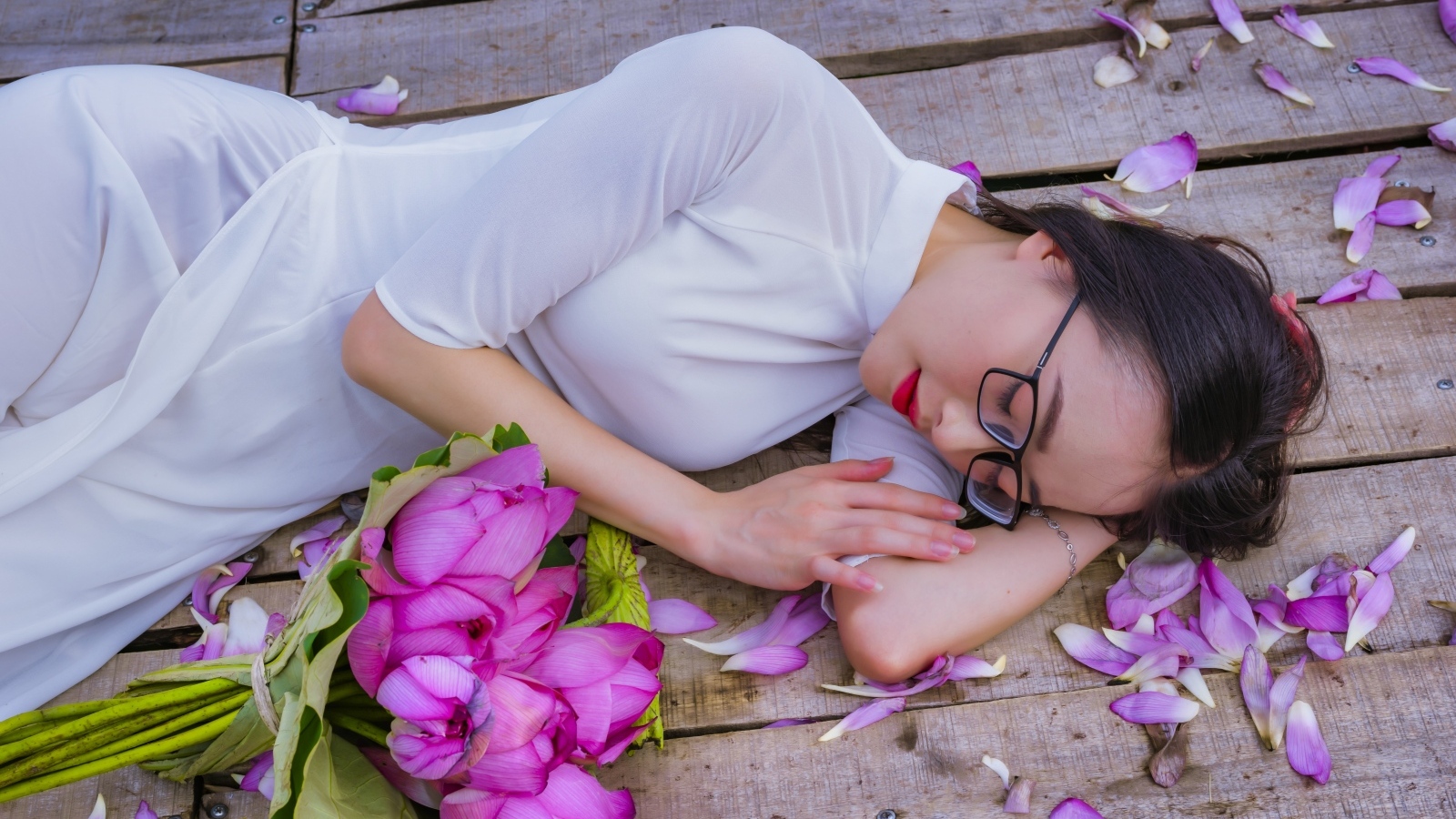 Девушка азиатка лежит с цветами лотоса