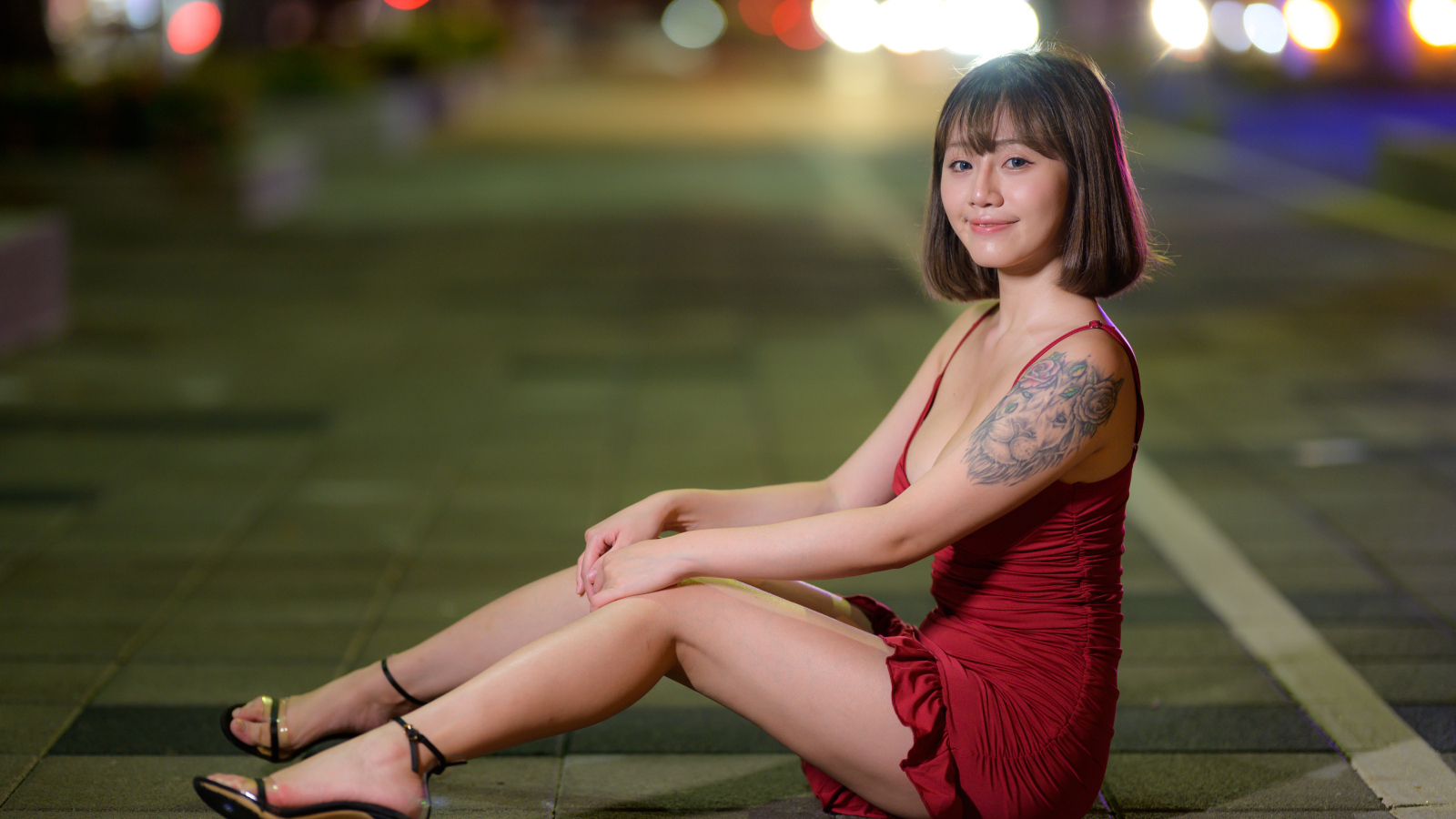 Азиатка с татуировкой на руке в красном платье