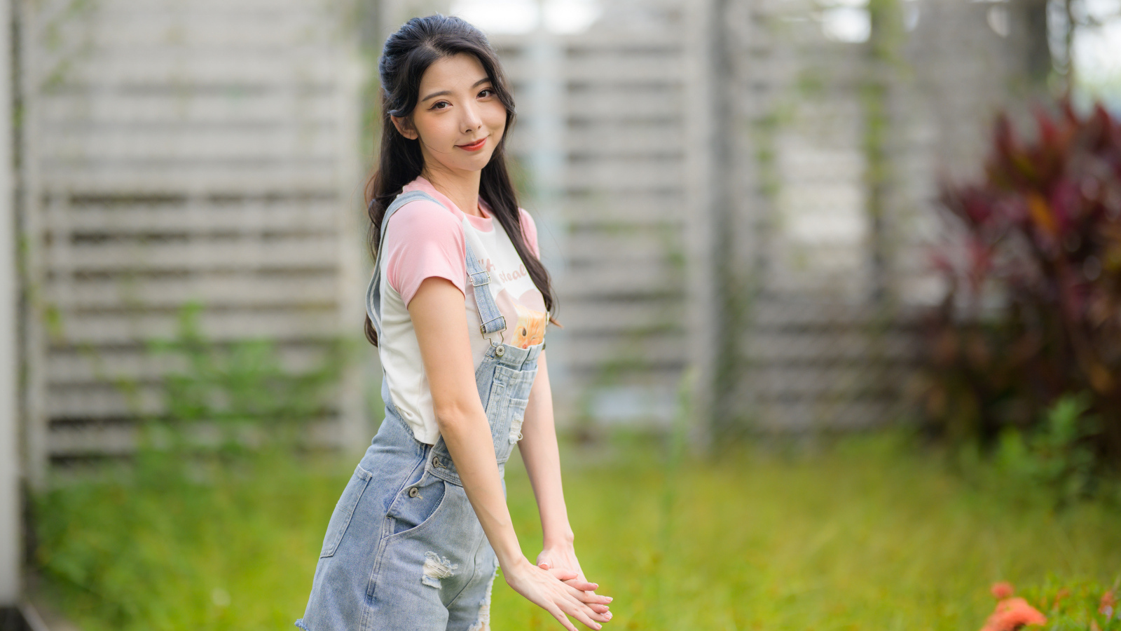 Милая девушка азиатка в джинсовом комбинезоне