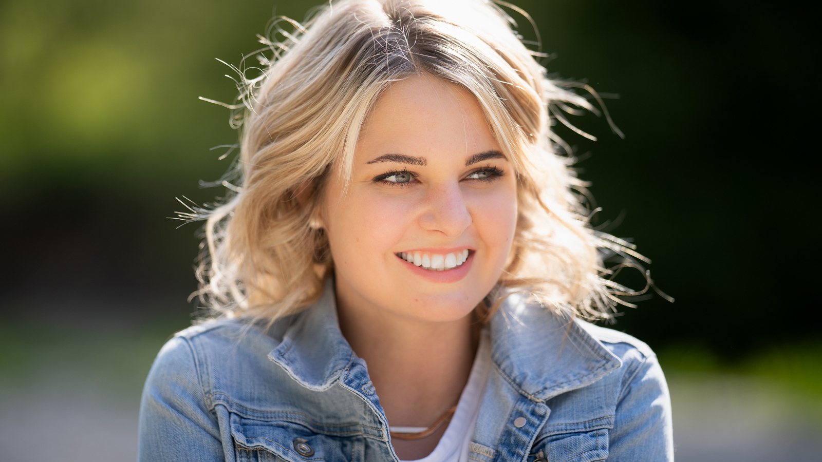 Улыбающаяся блондинка с красивыми белыми зубами
