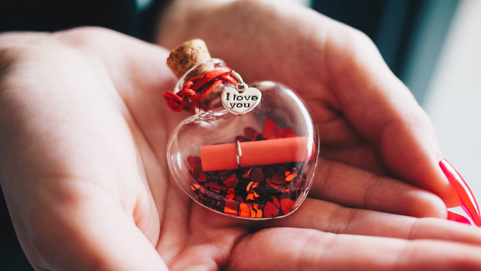 Ладони с маленький стеклянным сердечком