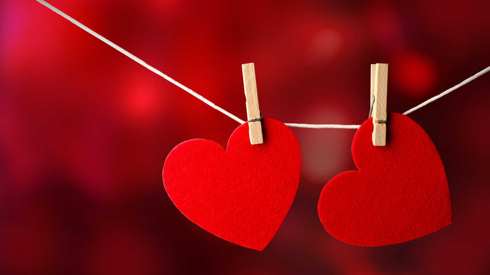 Два красных сердца висят на веревке