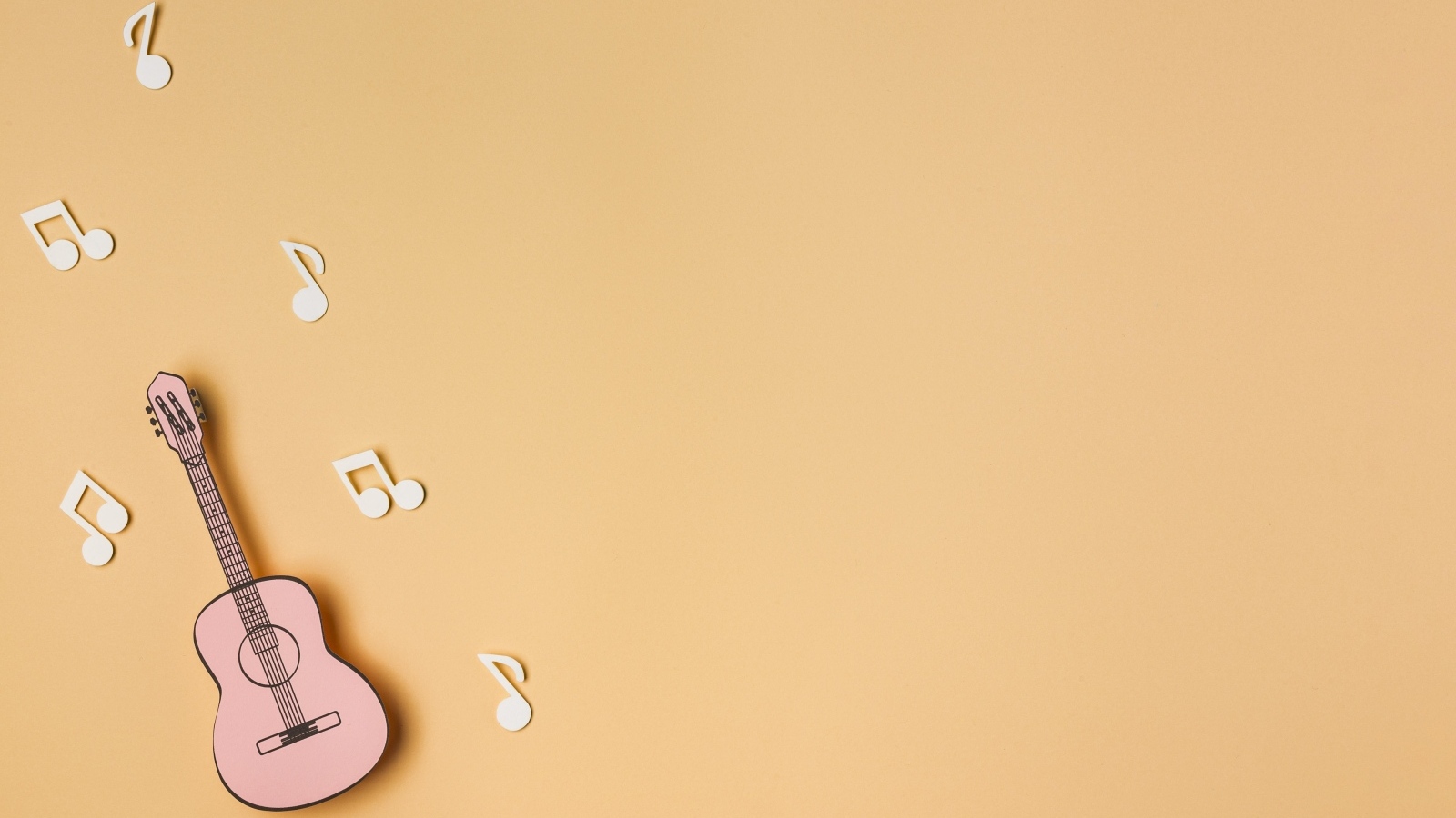 Маленькая гитара с нотами на бежевом фоне
