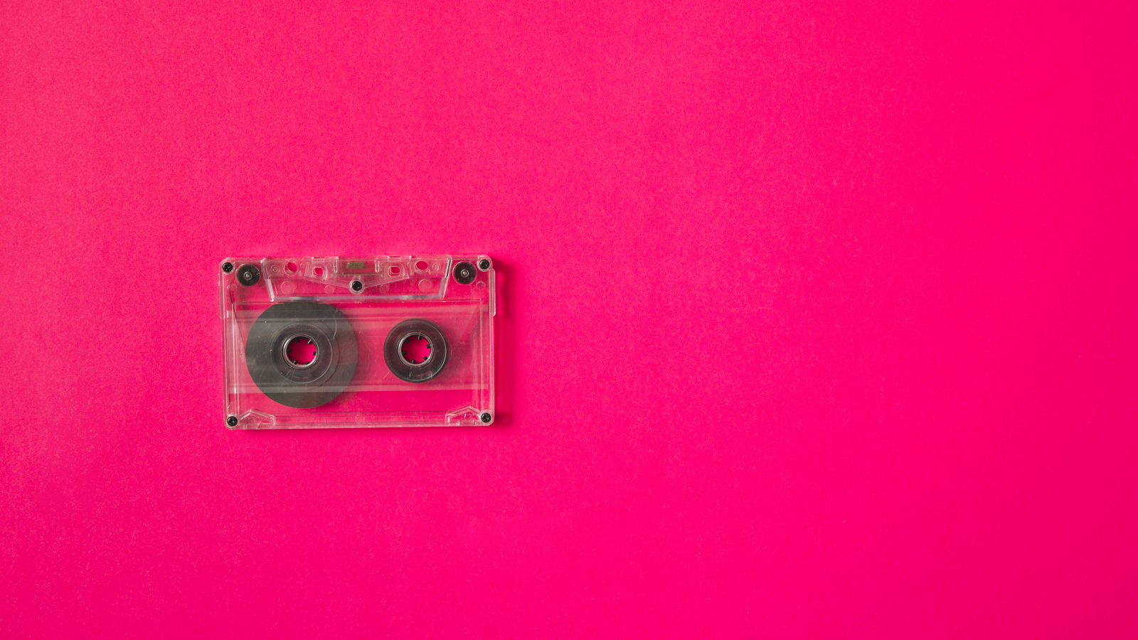 Маленькая магнитофонная кассета на розовом фоне