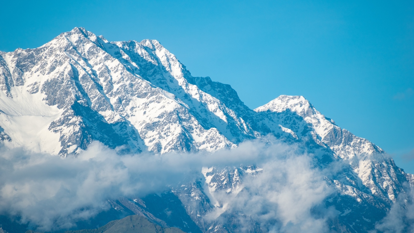 Высокие покрытые снегом горы на фоне голубого неба