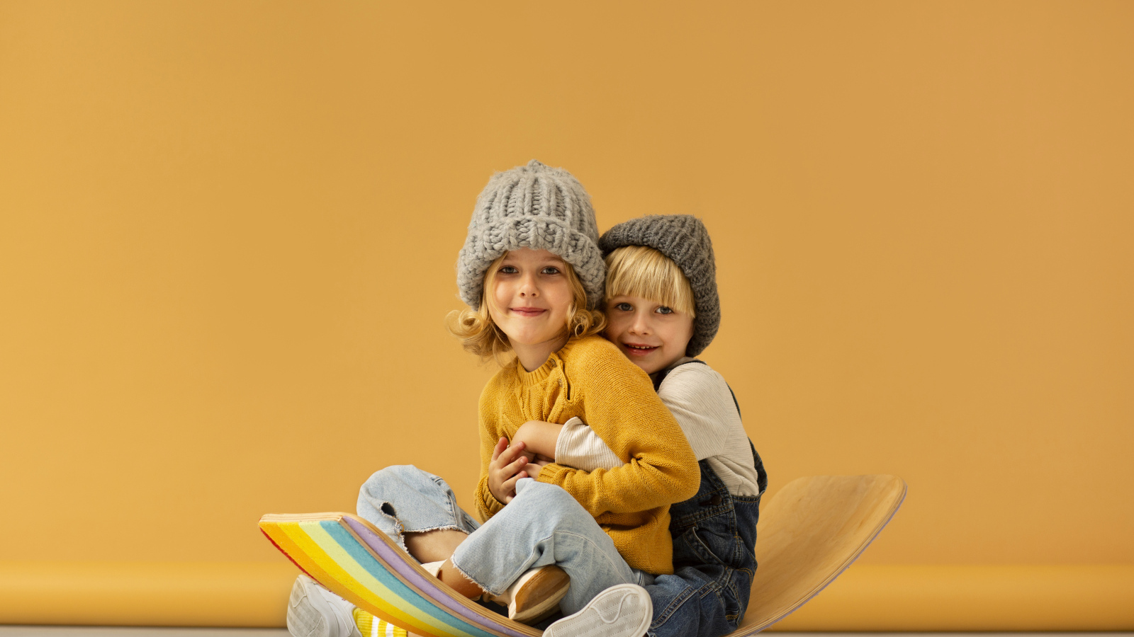 Счастливые брат и сестра в теплых шапках