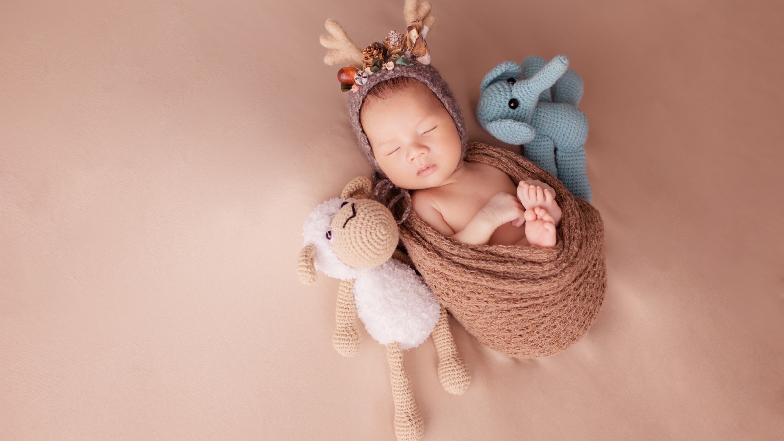 Маленький ребенок в костюме оленя с игрушкой