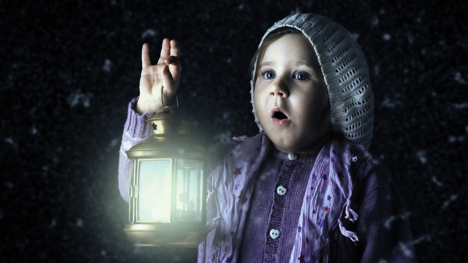 Удивленная маленькая девочка с фонарем в руках