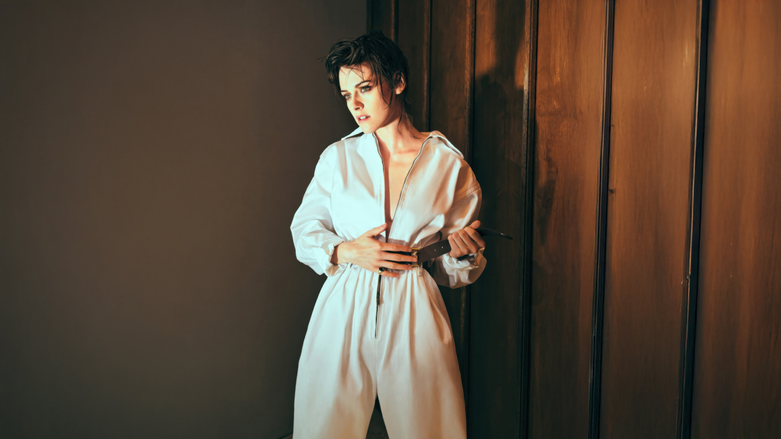 Американская актриса Кристен Стюарт в белом комбинезоне у стены