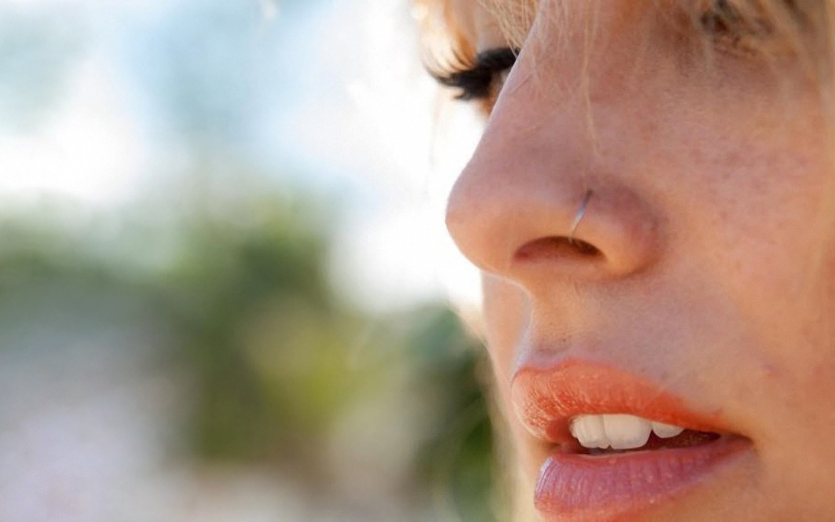 Девушка блондинка с пирсингом в носу крупным планом