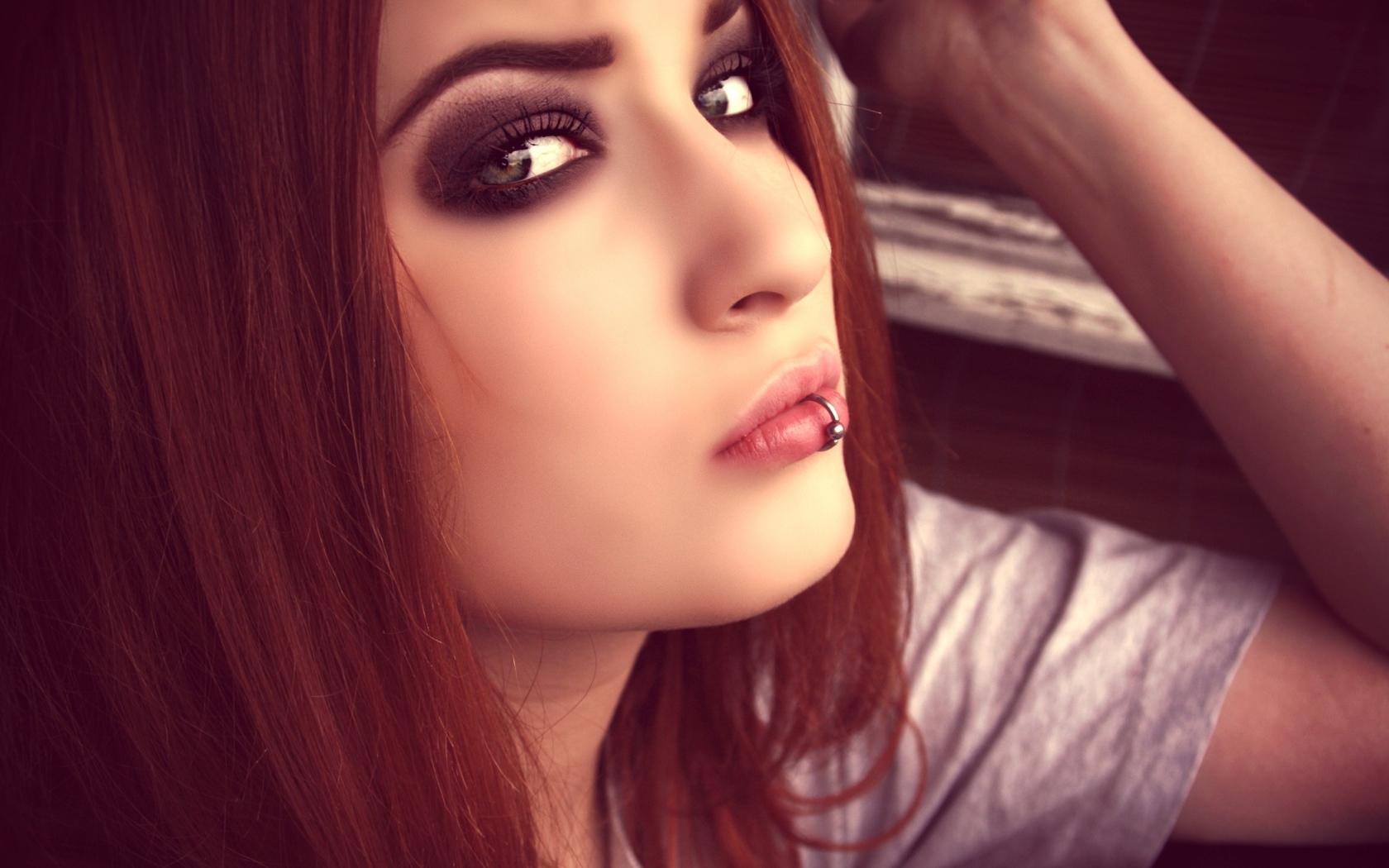 Молодая девушка шатенка с пирсингом в губе