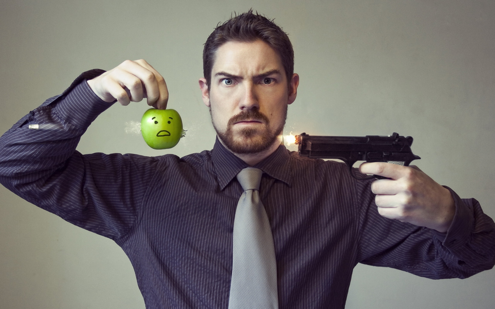 Мужчина стреляет в яблоко