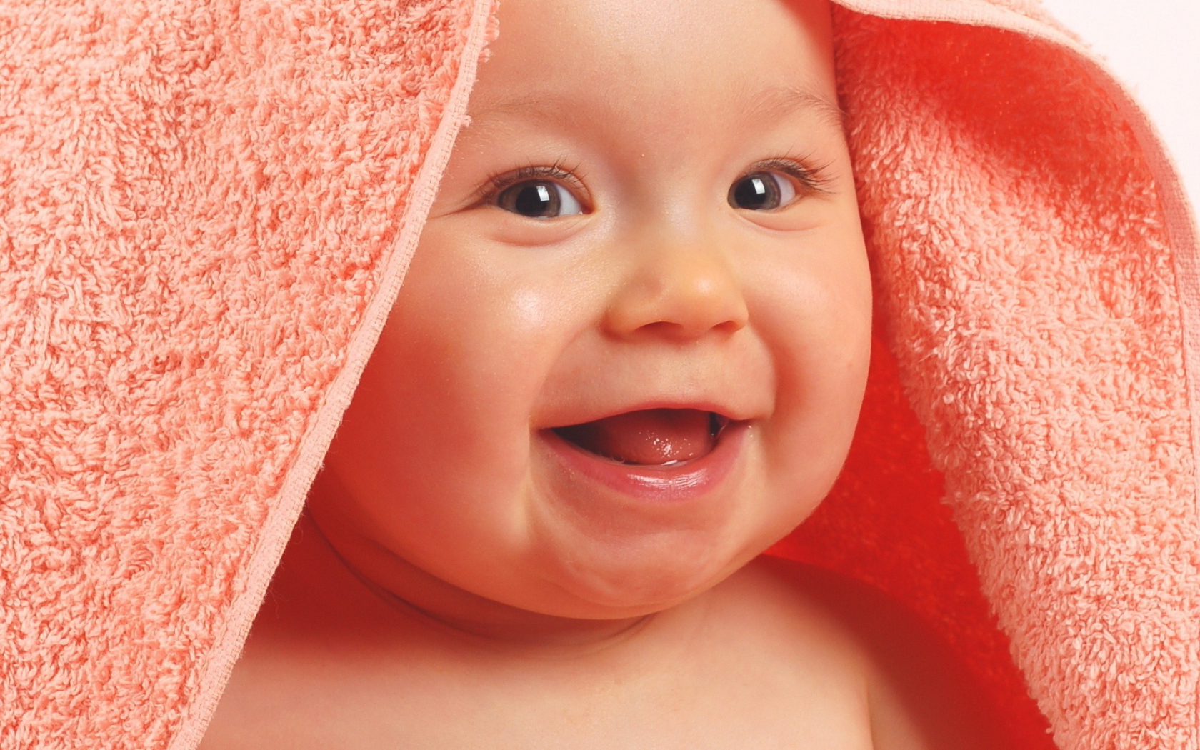 Ребенок в полотенце смеется