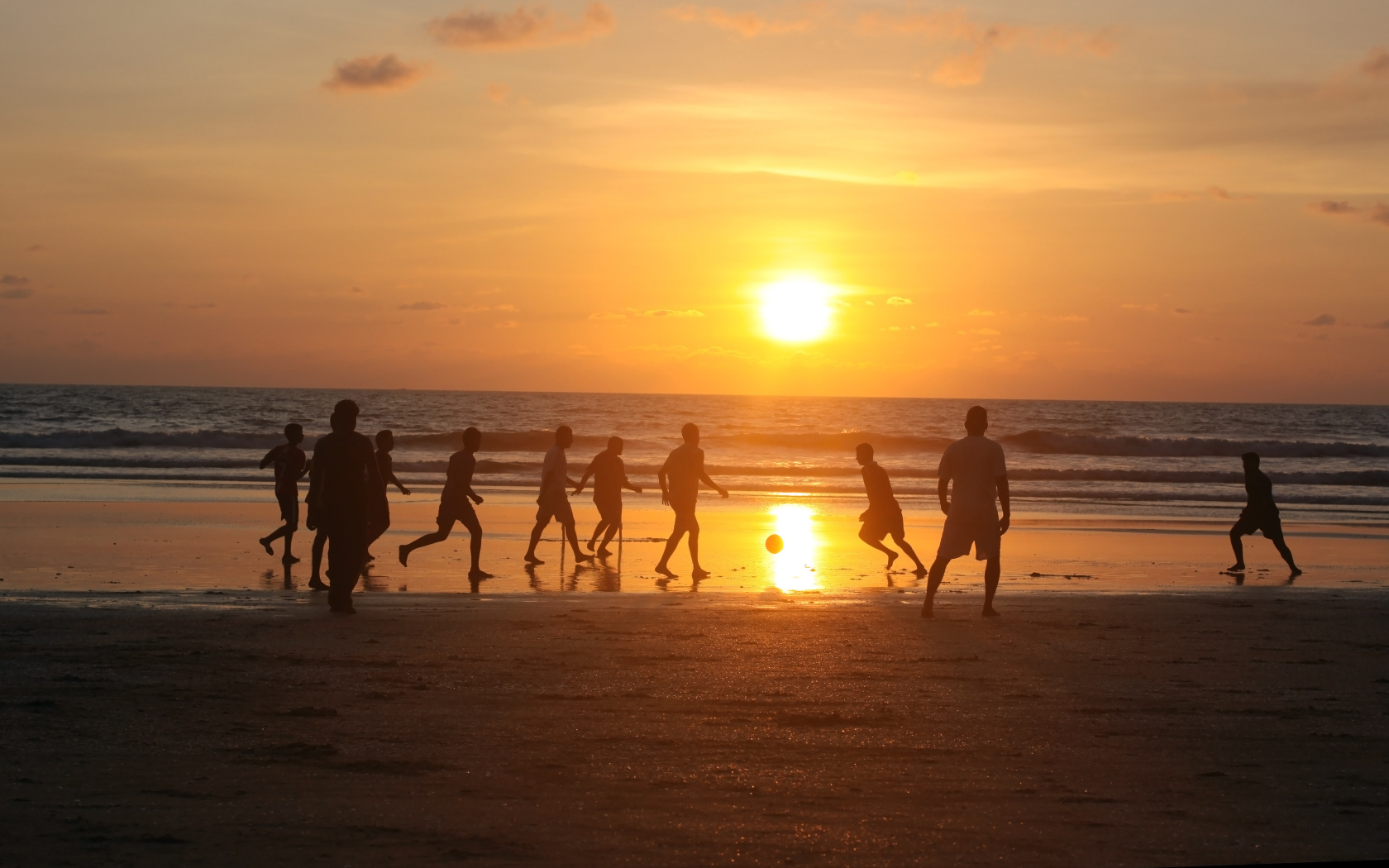 Парни играют в футбол на пляже в Гоа