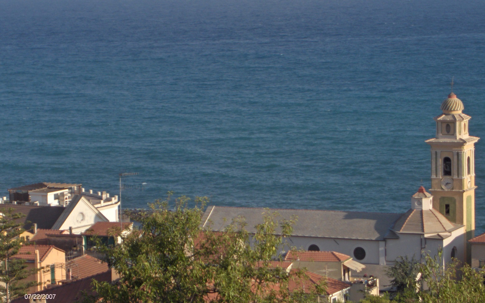 Башня с часами на фоне моря в Санто Стефано аль Маре, Италия