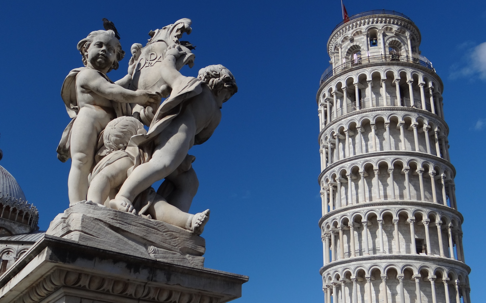 Статуя на фоне башни в Пизе, Италия