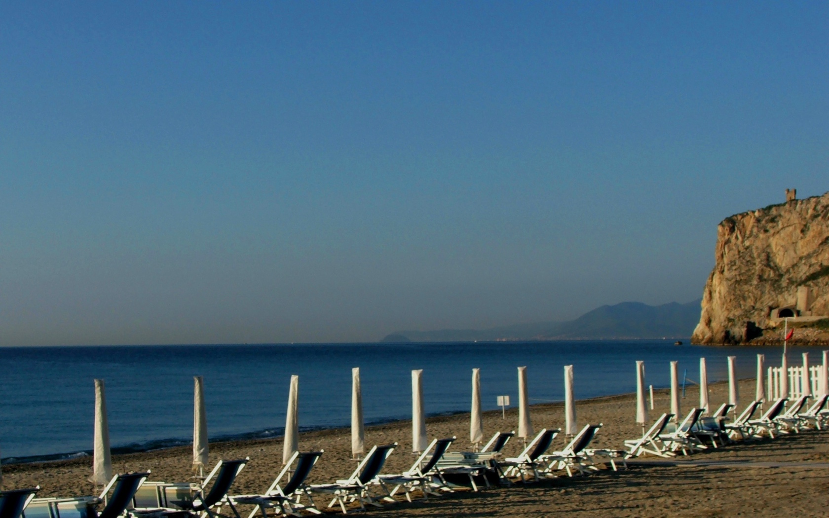 Лежаки на пляже на курорте Финале Лигуре, Италия