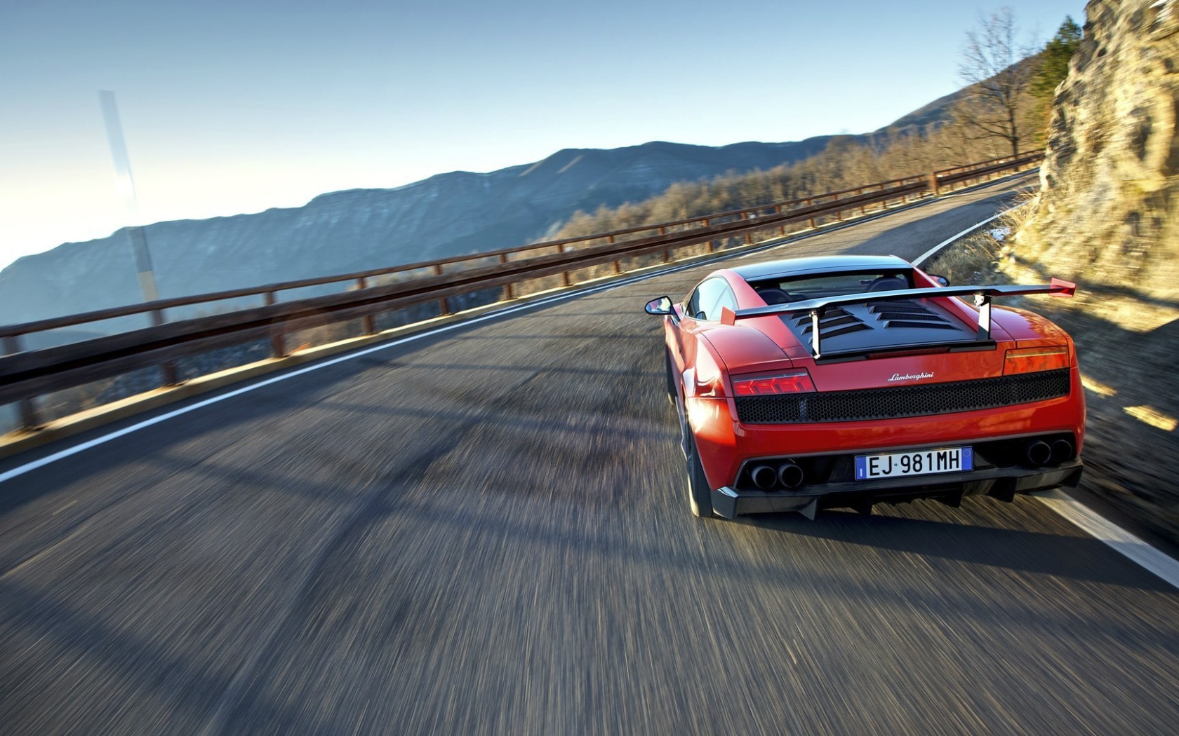 Красный гоночный автомобиль на горной дороге