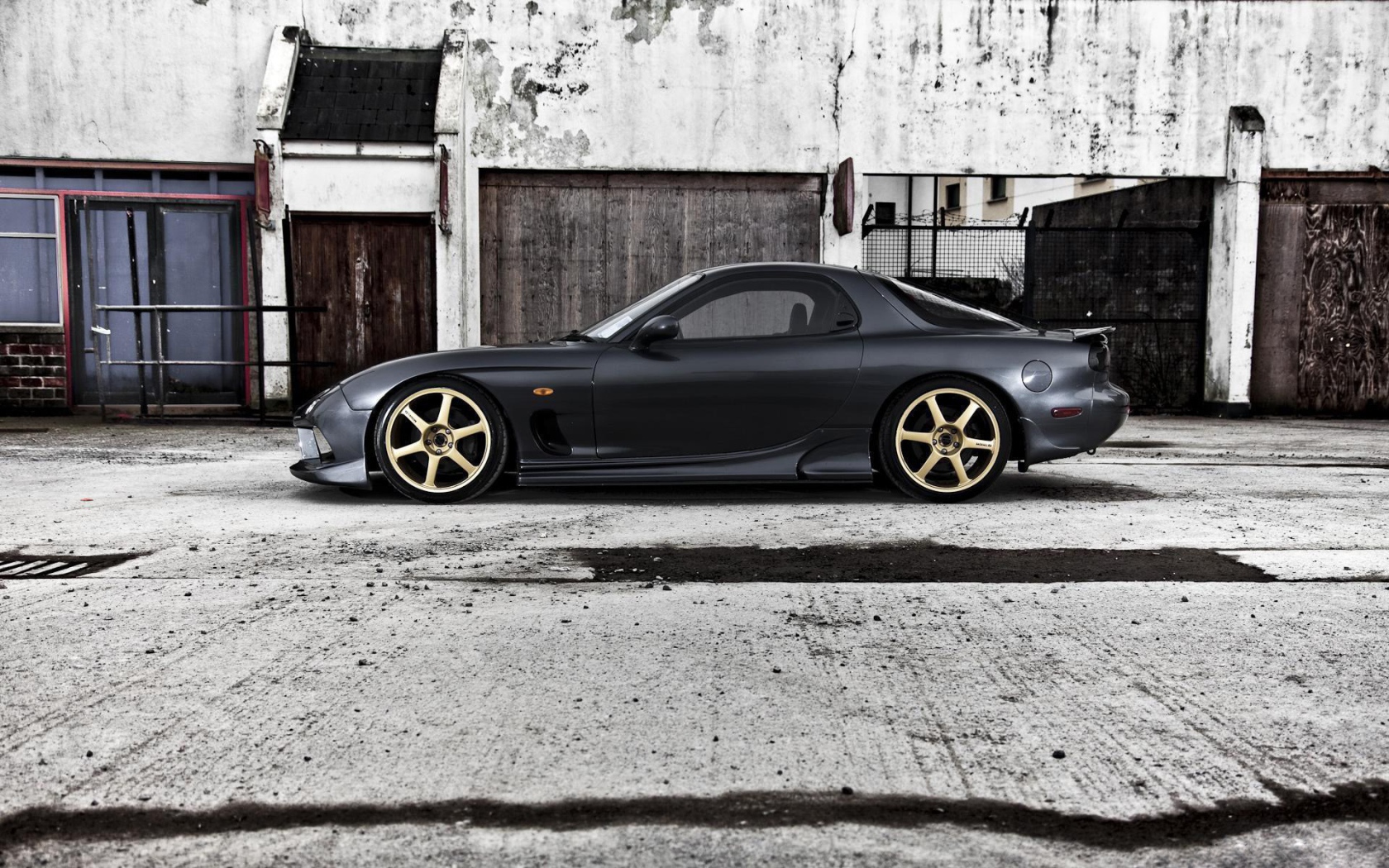 Черная Mazda RX-7 на сером бетоне