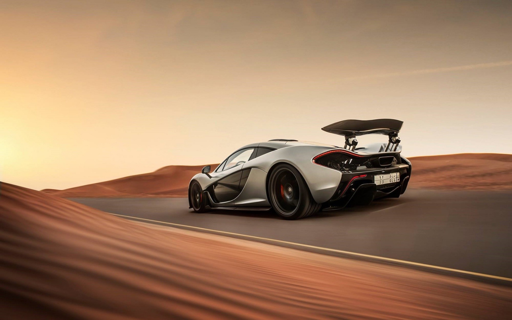 Серый McLaren P1 на шоссе в пустыне