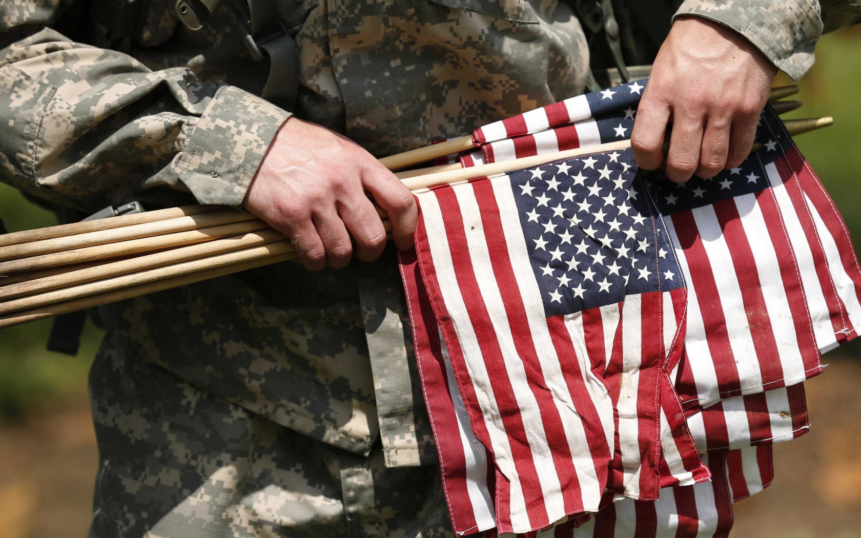 Солдат держит в руке флаги США