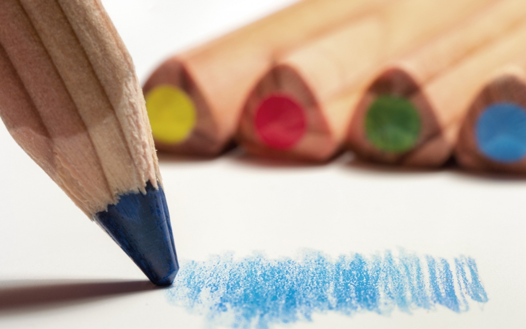 Карандаш синего цвета рисует по бумаге