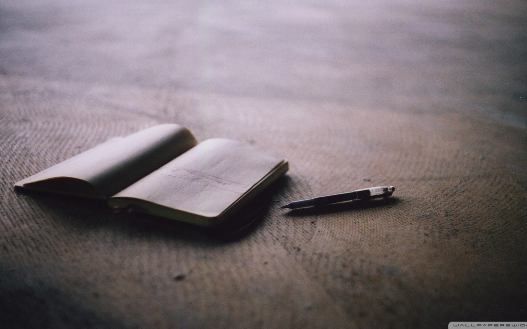 Записная книжка и ручка на полу