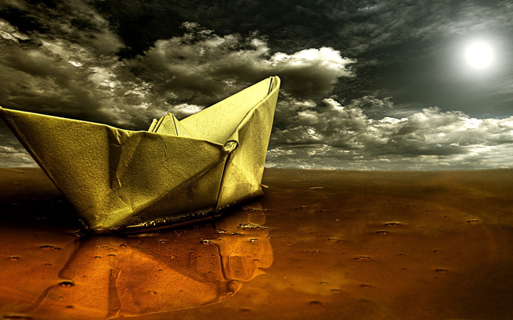 Корабль из бумаги на мокром песке