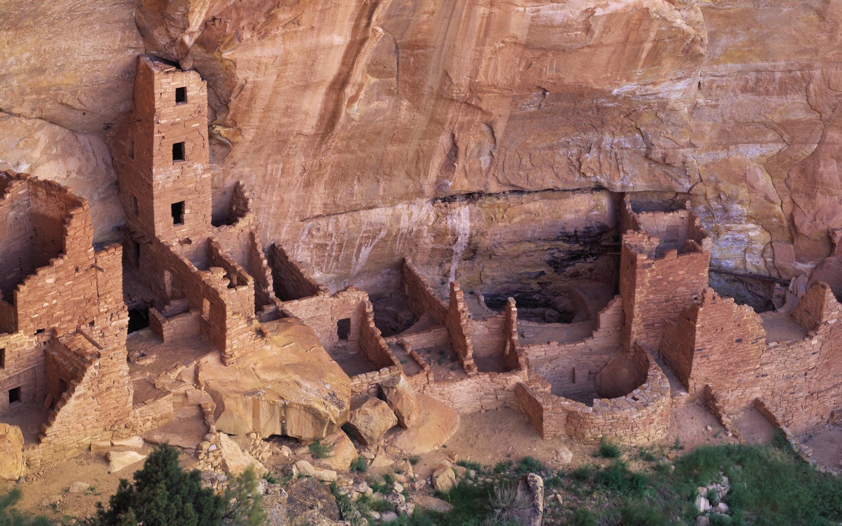 Руины каменных домов под скалой