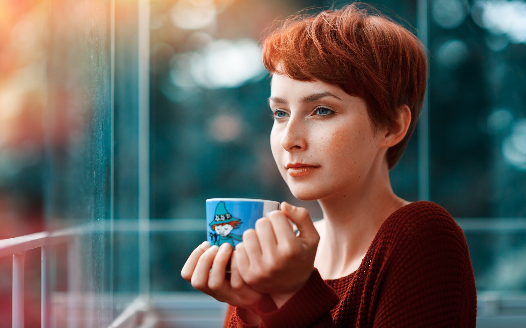 Девушка с короткими волосами пьет кофе