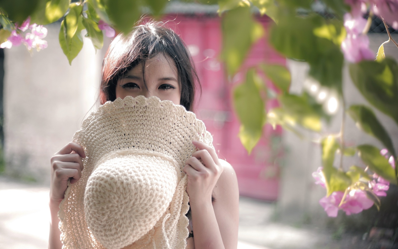 Азиатская девушка прикрыла лицо шляпой