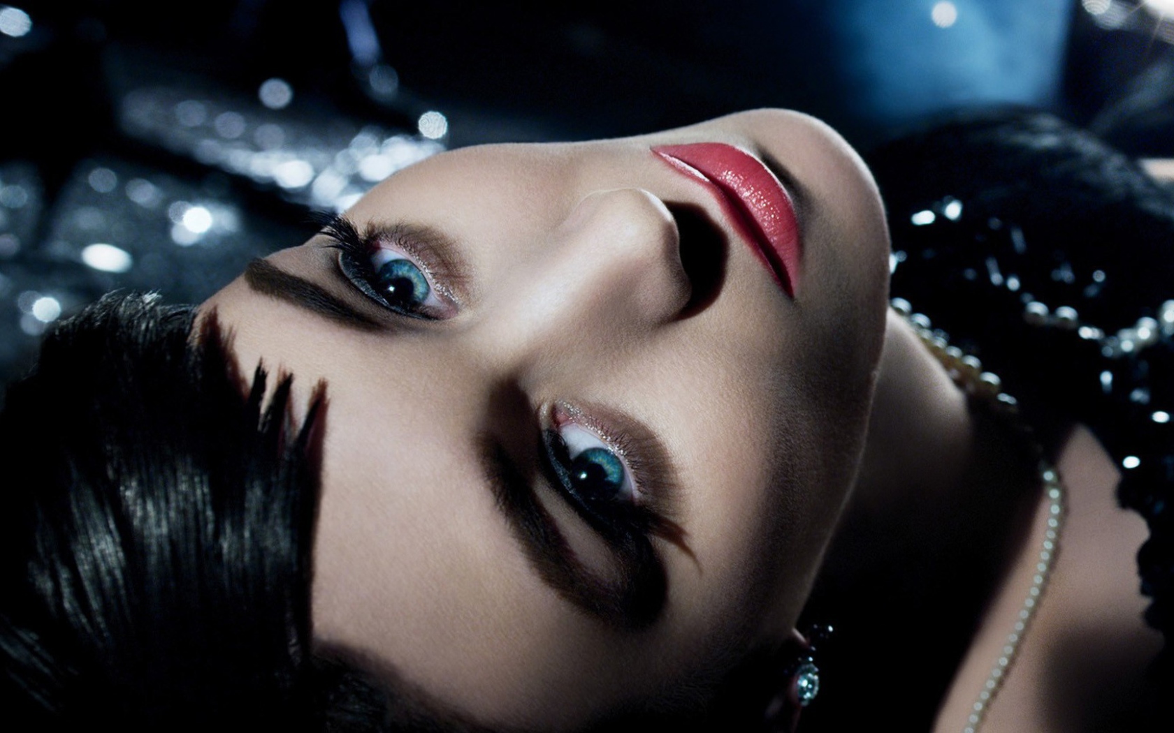 Голубоглазая брюнетка лежит в черном платье