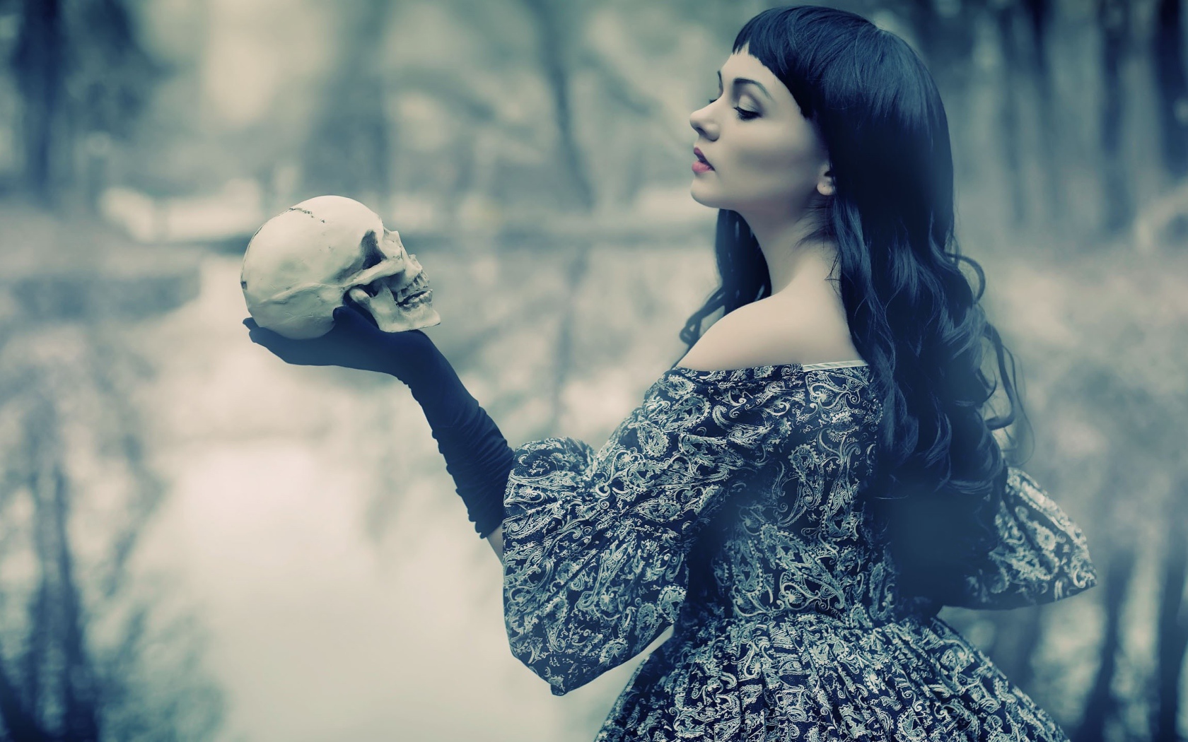 Брюнетка держит в руке череп