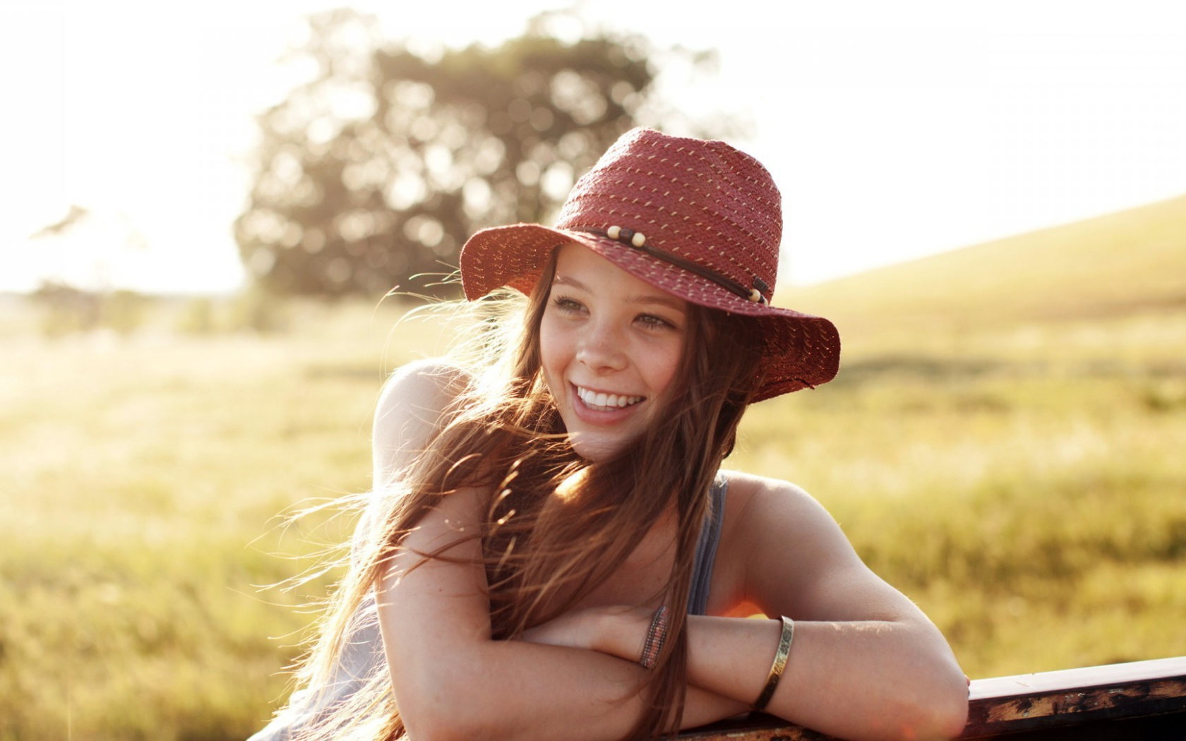 Веселая девушка в легкой красной шляпе