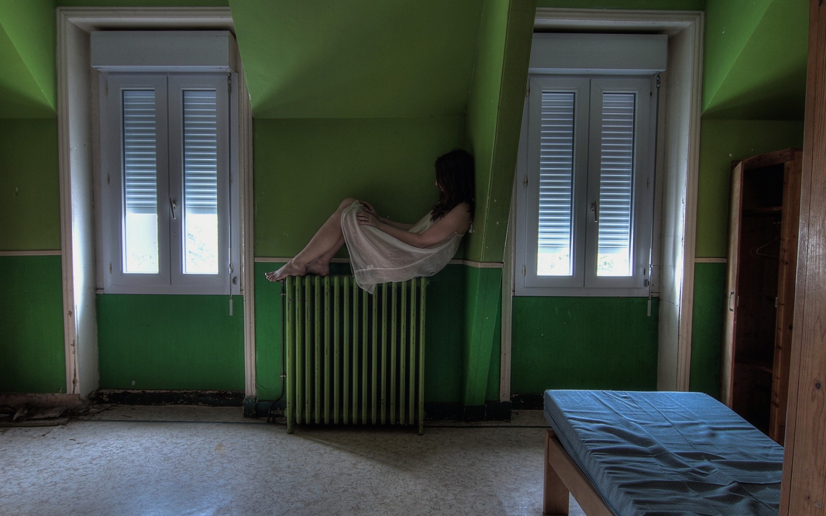 Девушка в ночной рубашке сидит на батарее