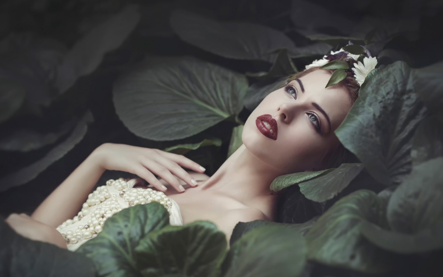 Девушка лежит в больших листьях