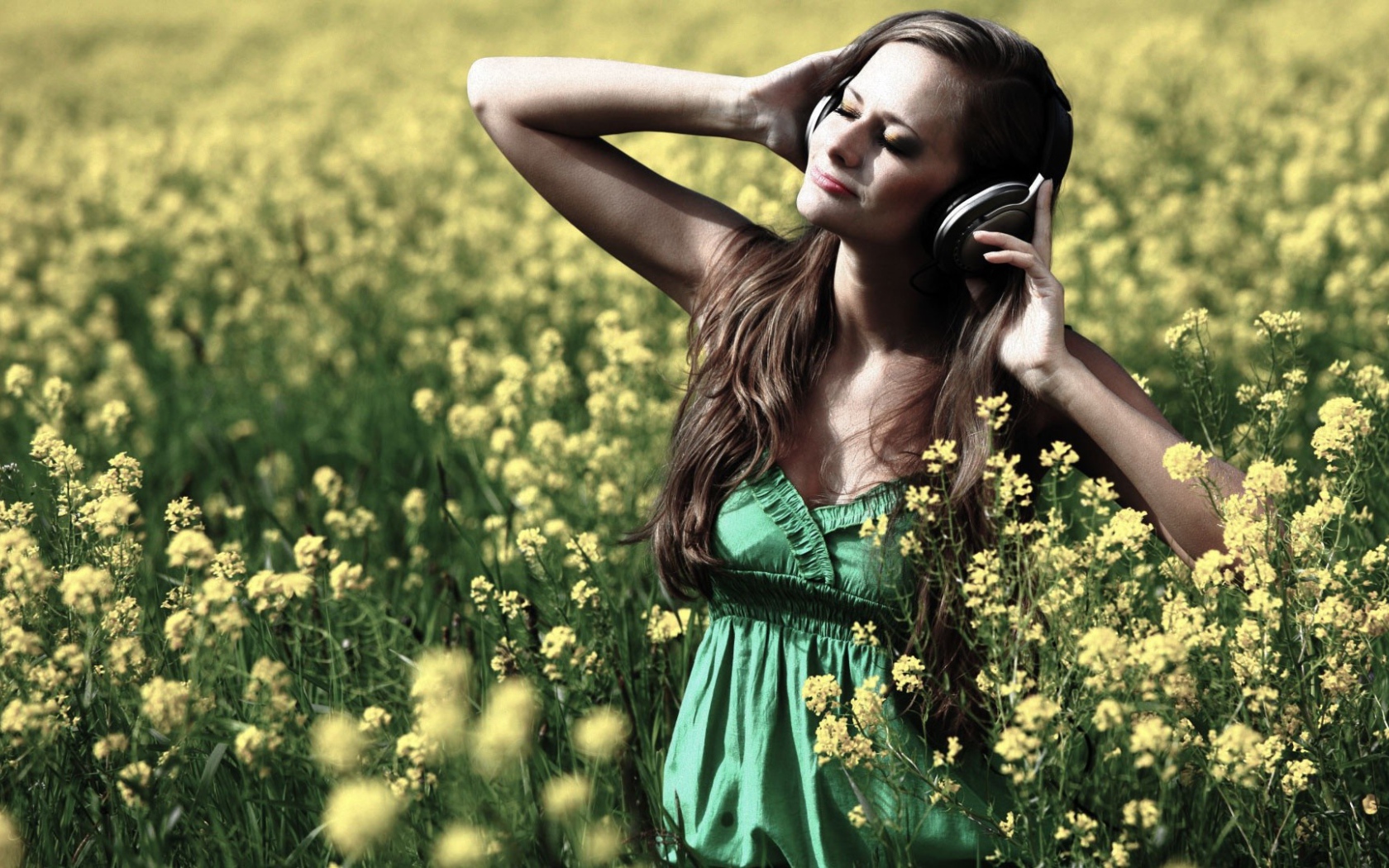 Девушка стоит среди цветов в наушниках