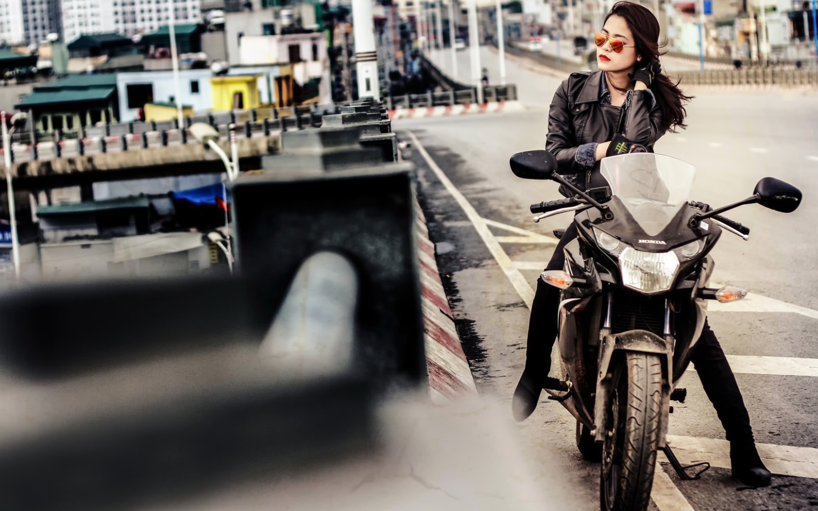 Девушка в темных очках сидит на мотоцикле