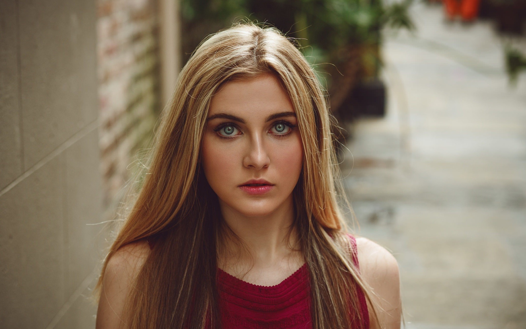 Блондинка с зелеными глазами идет по улице