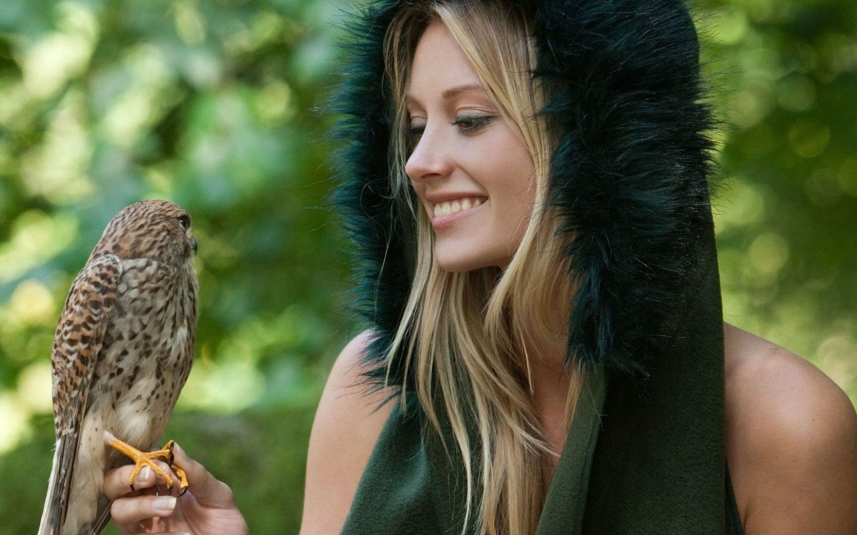 Девушка в меховой накидке держит на руке птицу