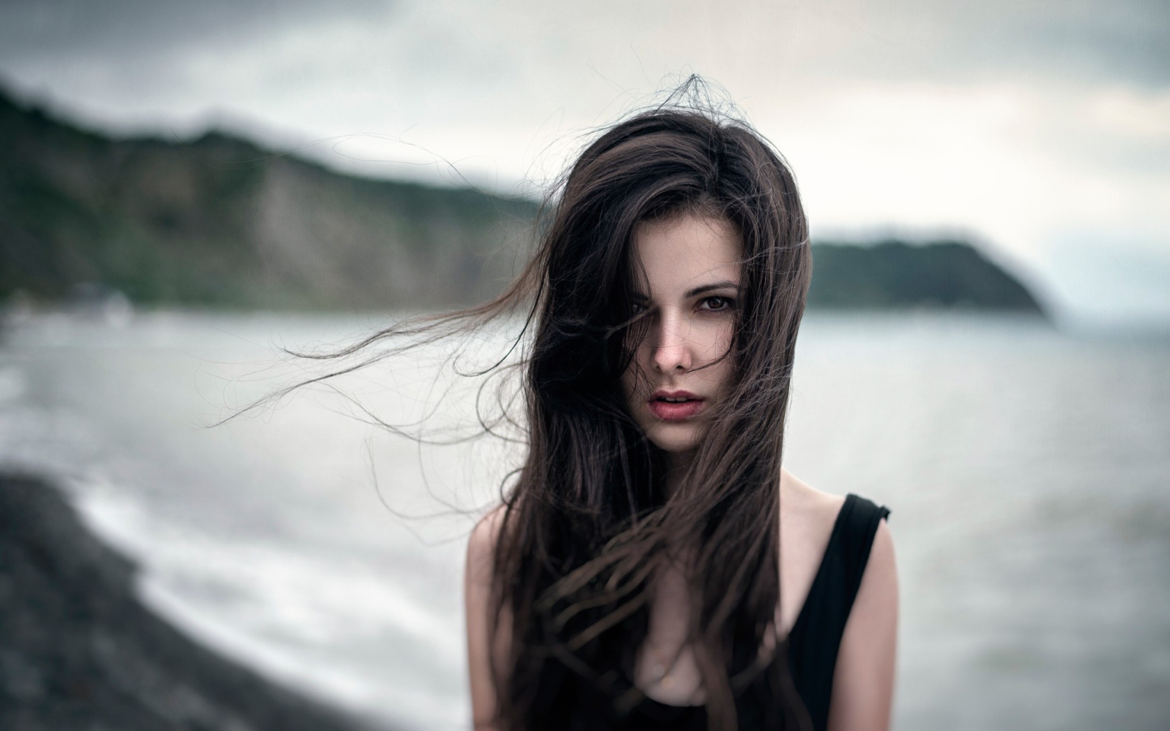 Ветер треплет волосы девушки у моря, портрет