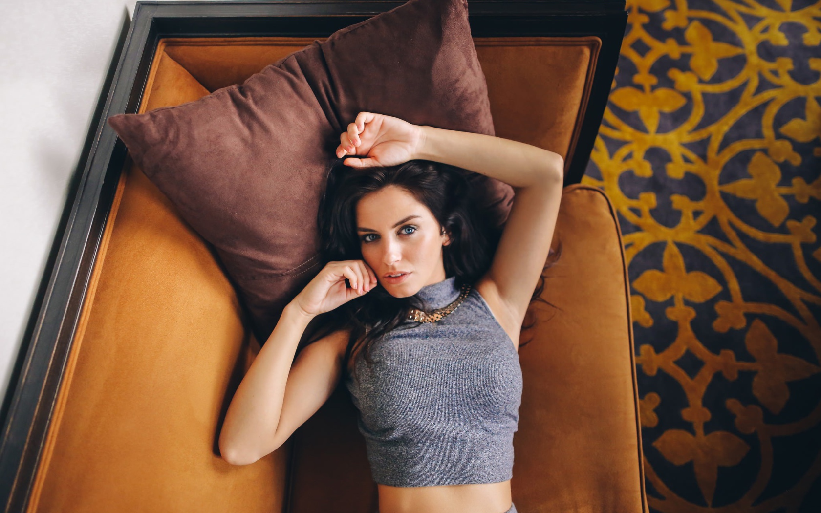 Модель Aurela Skandaj лежит на диване