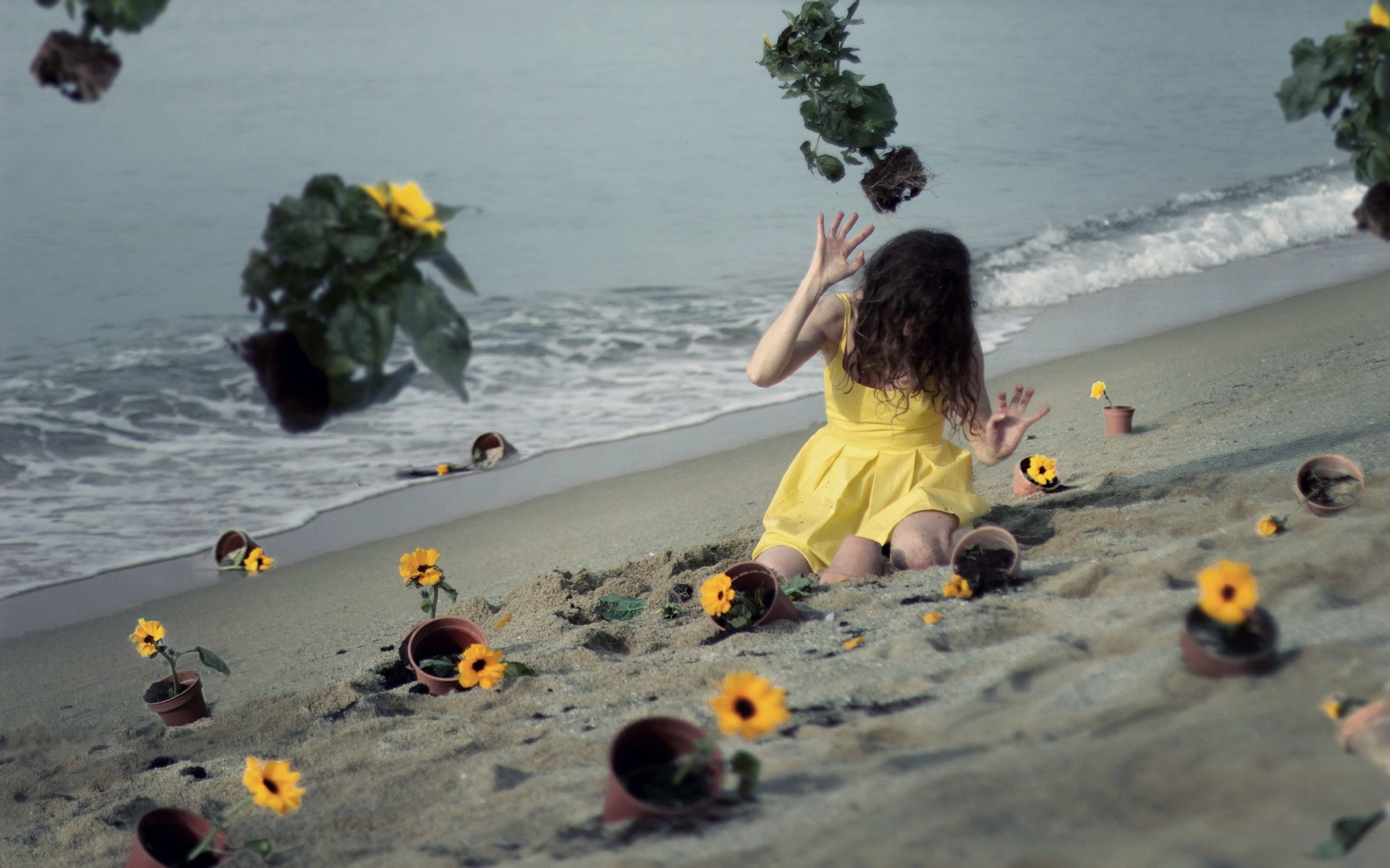 Модель в желтом платье среди цветов на пляже