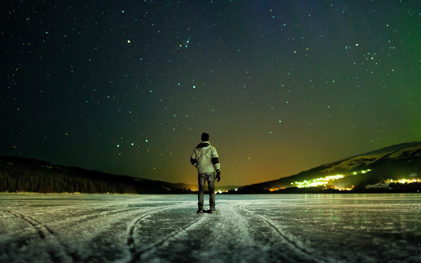 The man on the ice looking up at the stars
