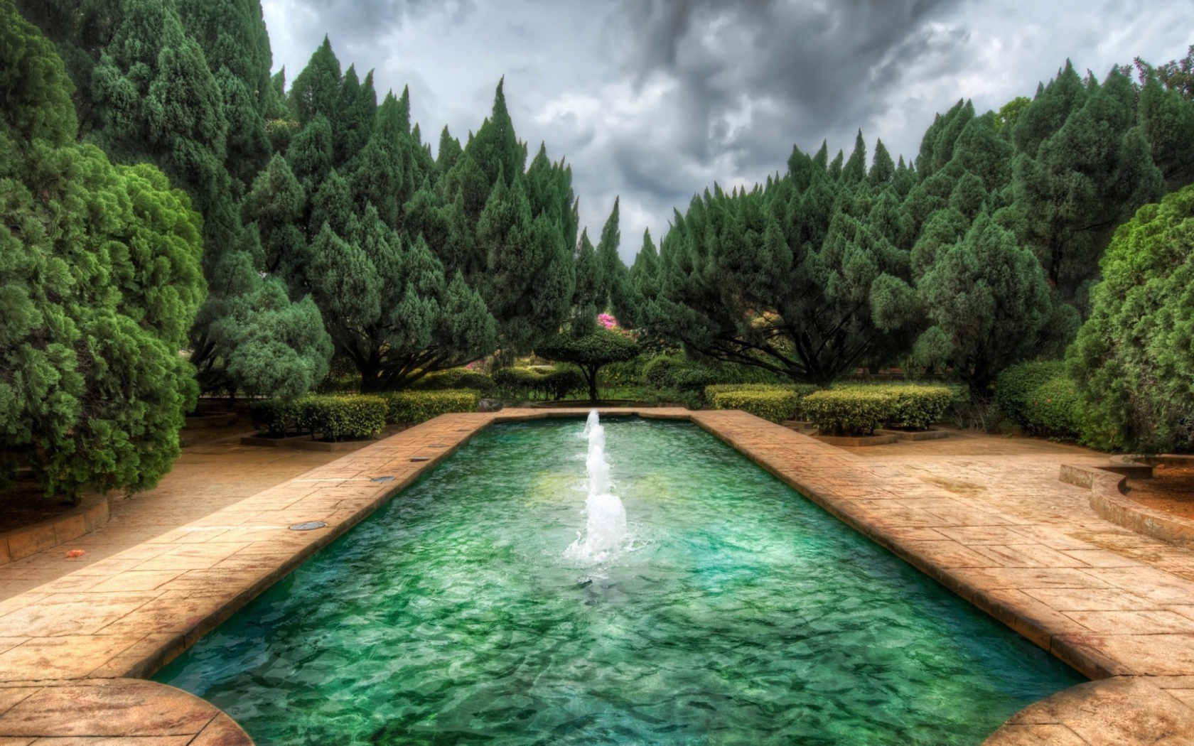 Пруд с фонтанами в саду