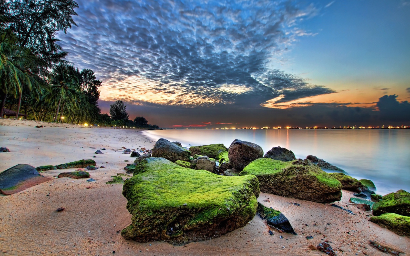 Зеленые камни на песке пляжа