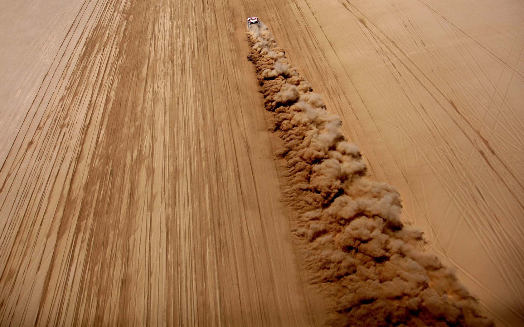 Облако пыли за автомобилем в пустыне