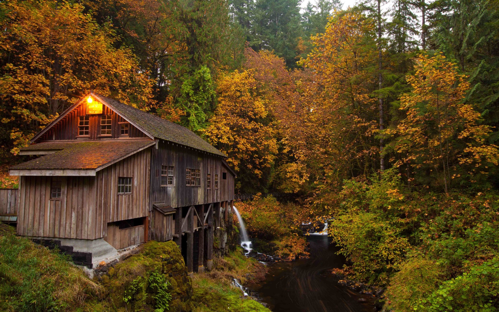 Деревянный дом над речушкой в лесу