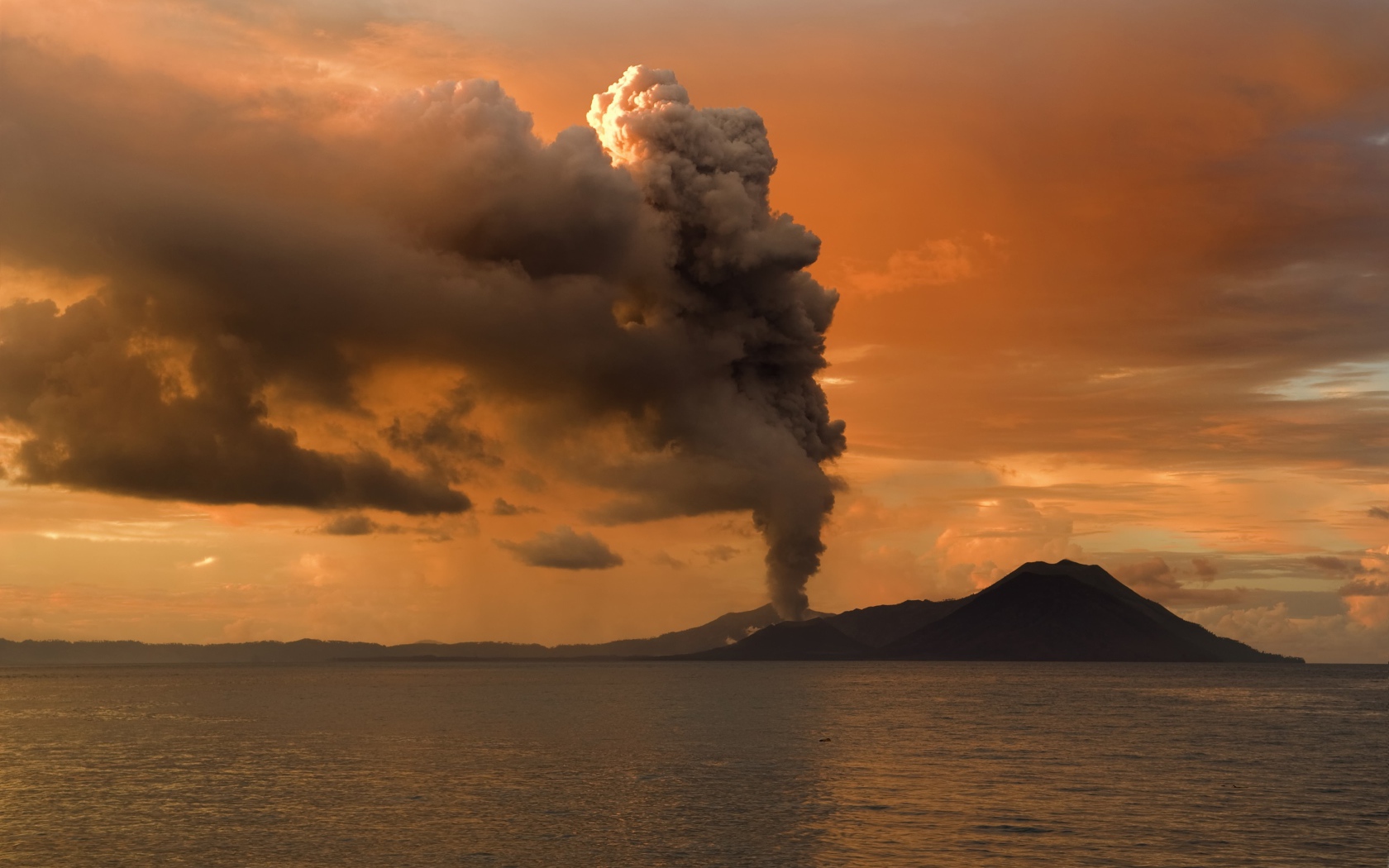 The eruption of a volcano on an island in the sea